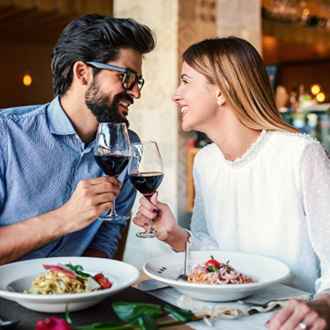 Couple smiling while enjoying meal at restaurant