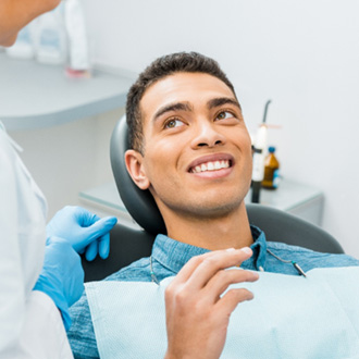 Patient smiling while holding small mirror