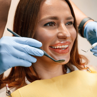 Woman with Invisalign smiling during visit