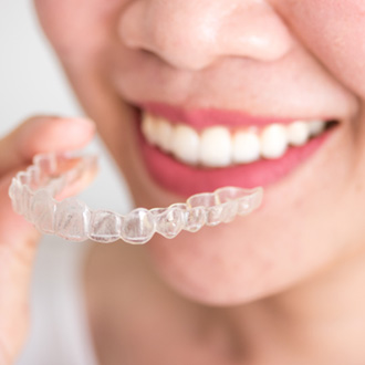Closeup of patient holding clear aligner