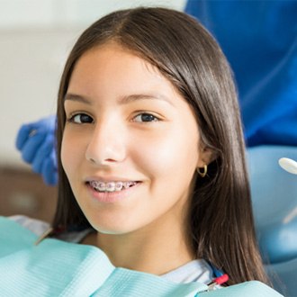 Young girl with braces smiling in treatment chair