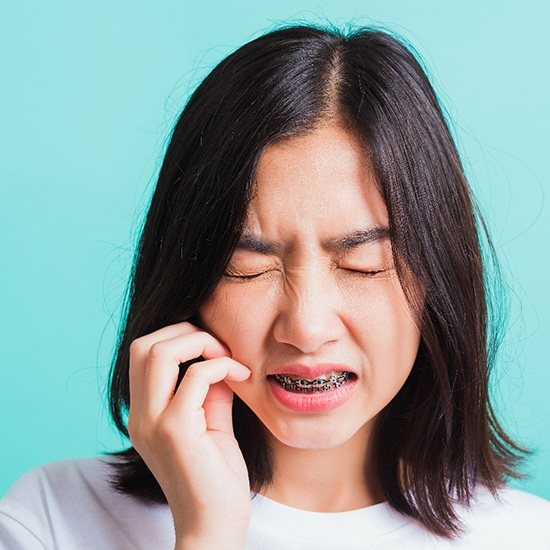 Closeup of girl experiencing toothache with braces